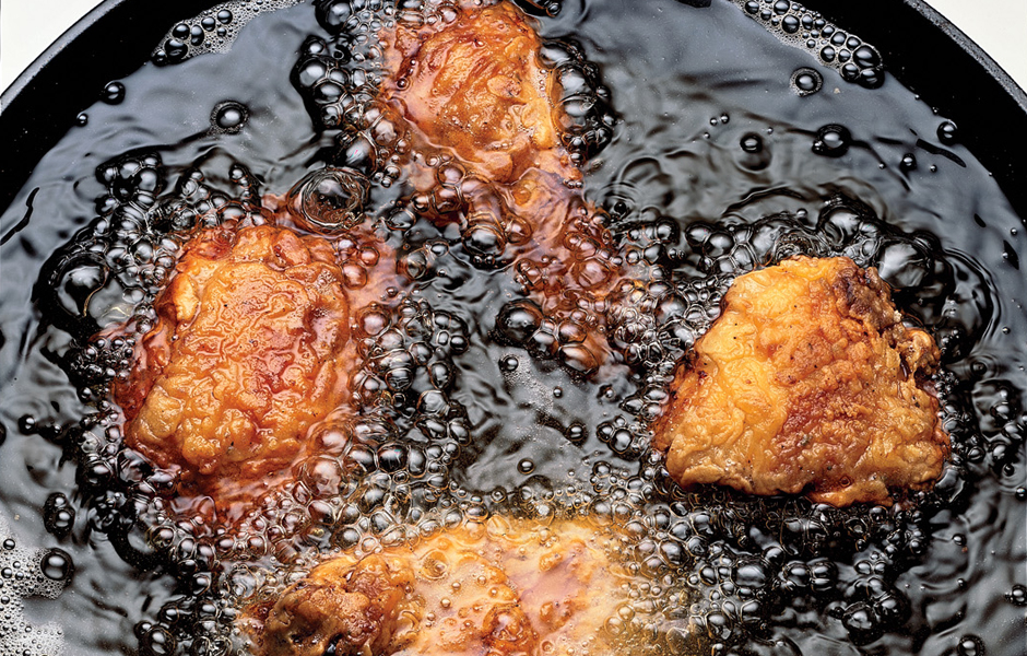 Chicken being fried in fat
